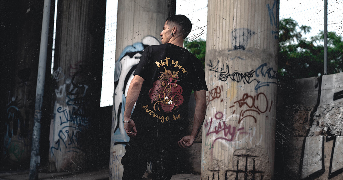 Tokyo Joe’s employee wearing updated uniform t-shirt featuring new back design in urban, graffiti-covered setting